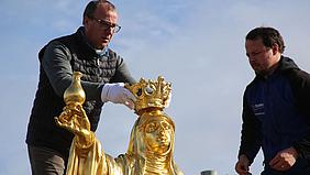 Kirchenmaler Gerhard Hammerschmid setzt der hl. Walburga die Krone auf. Foto: Geraldo Hoffmann